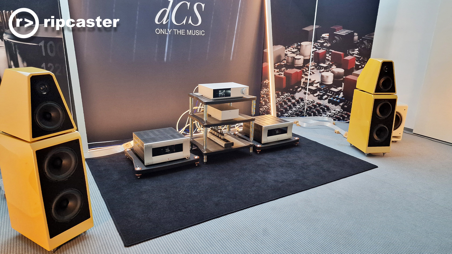 A closer view of the yellow floorstanding speakers with HiFi equipment between them.