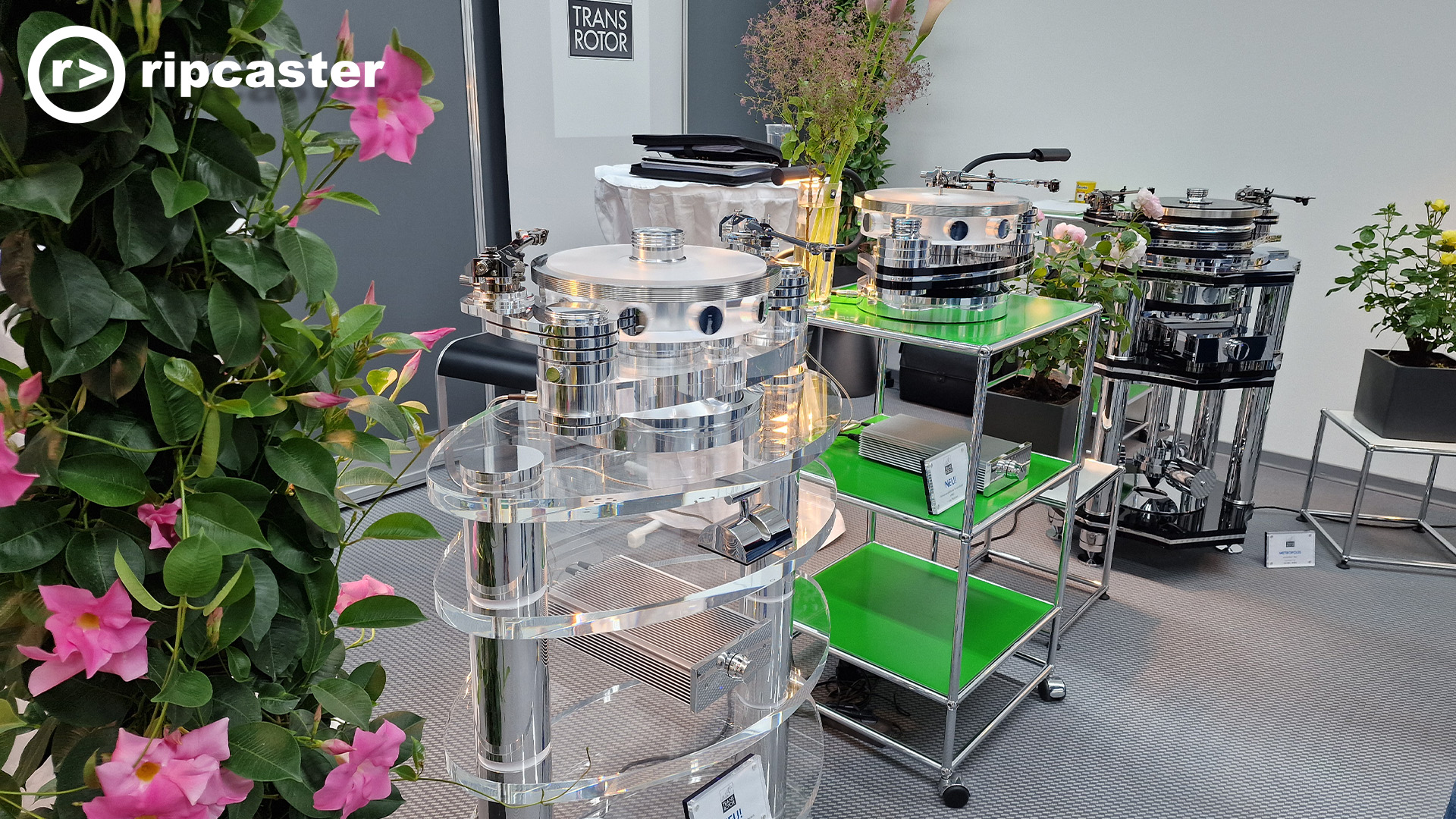 Flowers mixed among turntables on high stands.