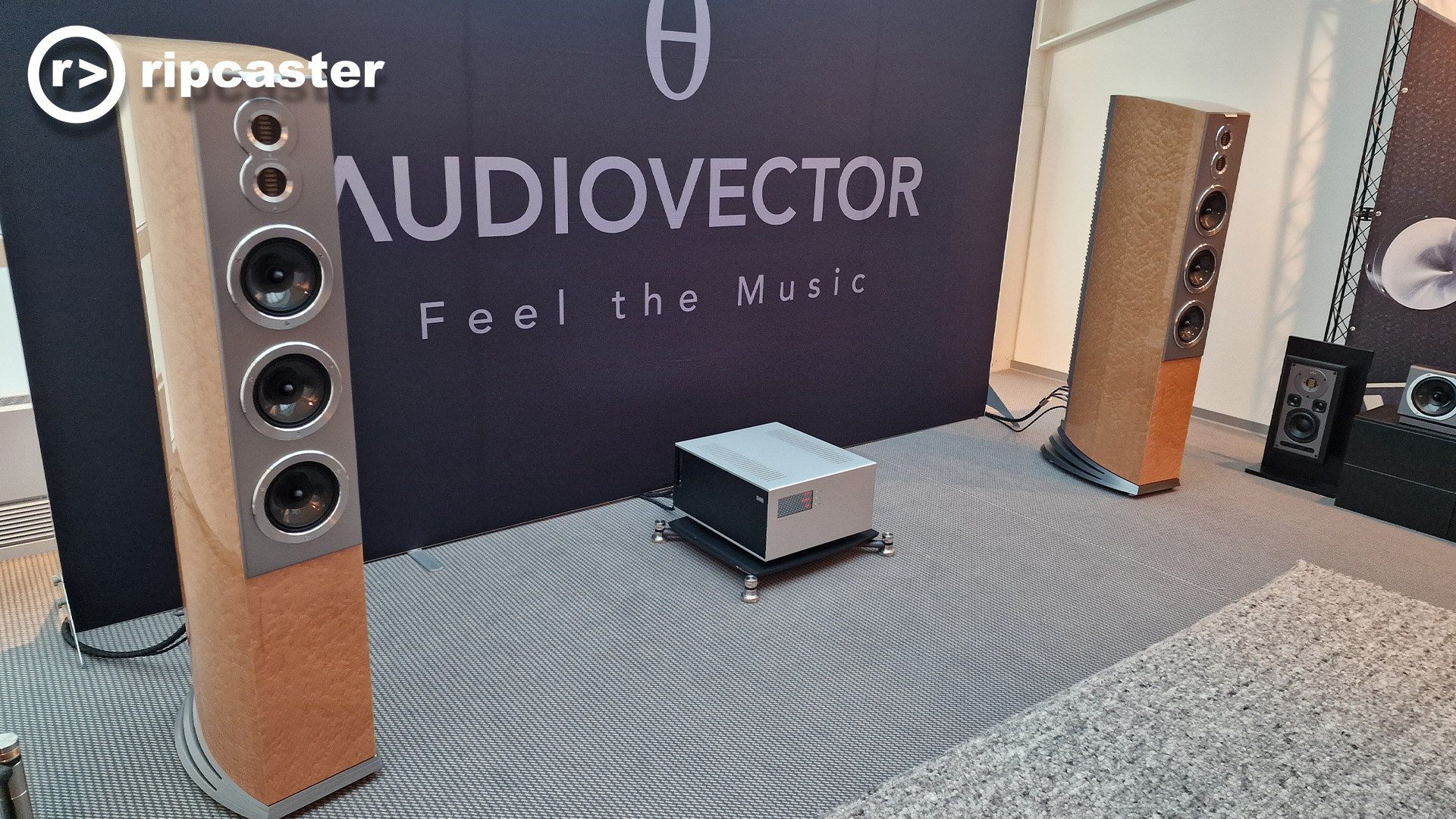 Audiovector floorstanding speakers either side of the Audiovector sign