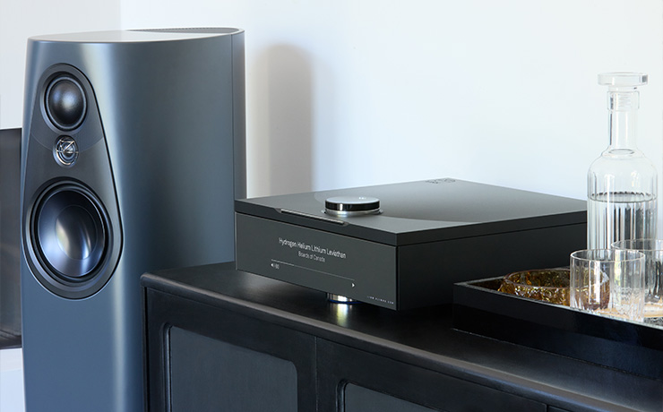 The Linn 343 speaker standing beside a black unit that has a Linn DSM sitting on the top