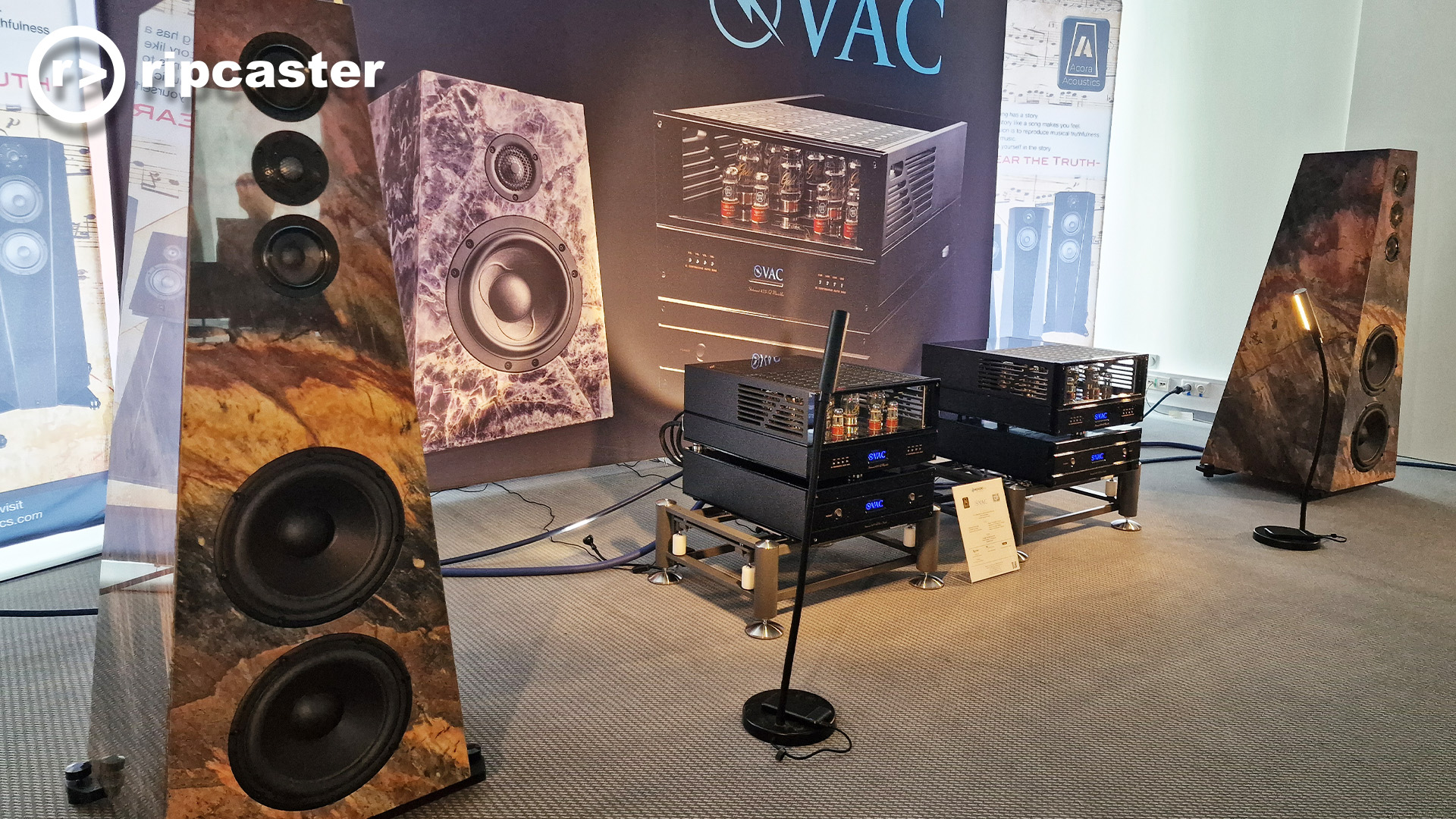 Speakers with a finish that looks like an abstract painting of the countryside.  HiFi kit between the two speakers