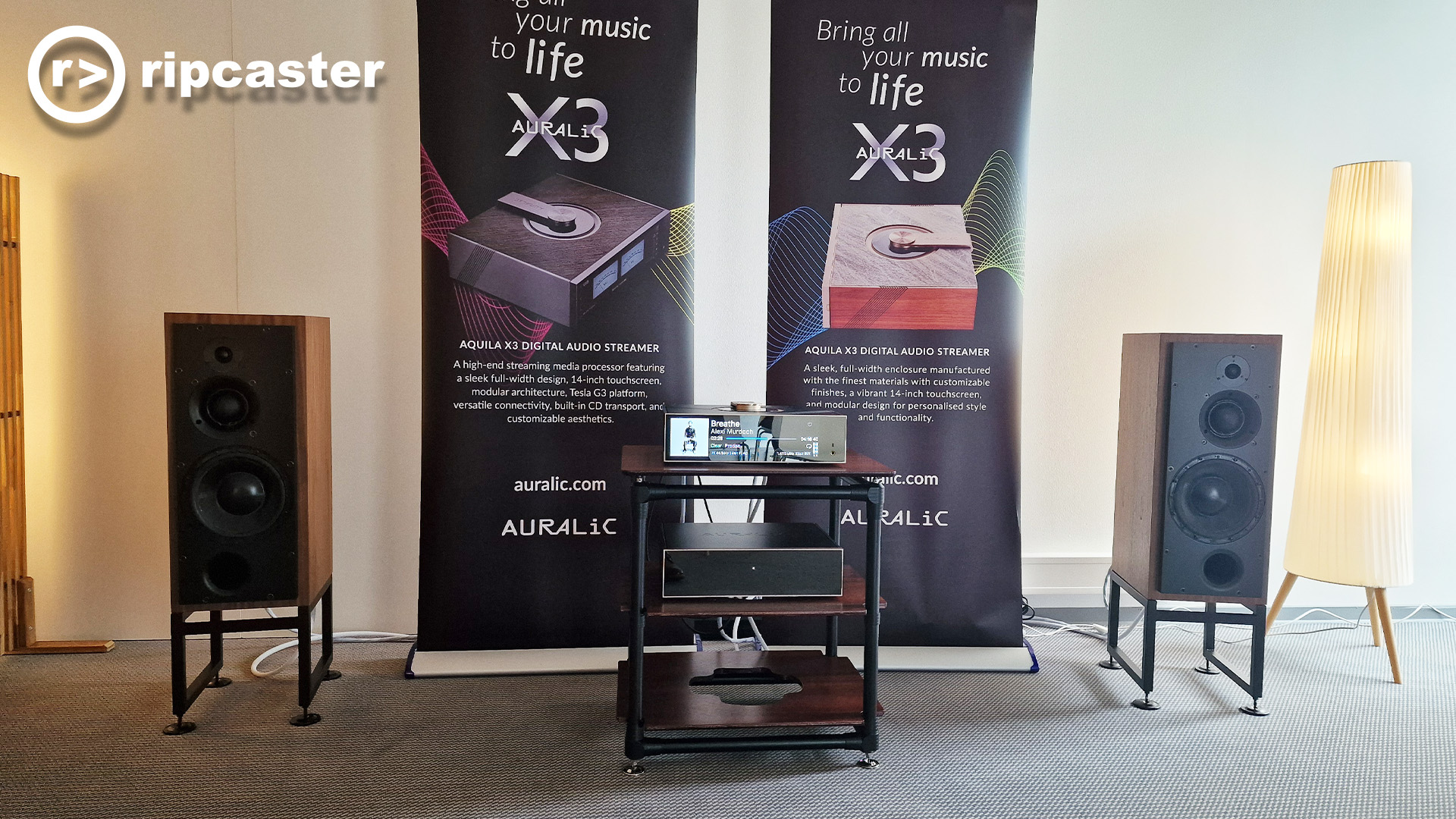 The Auralic room at the Munich HiFi Show with two speakers either side of a HiFi rack of HiFi boxes.