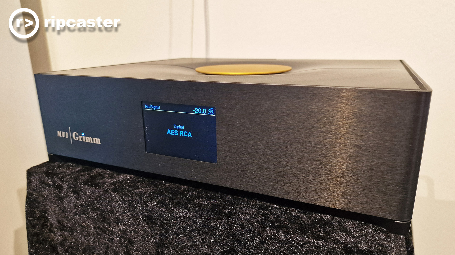 The Grimm MU1 on top of black fabric draped over a stand