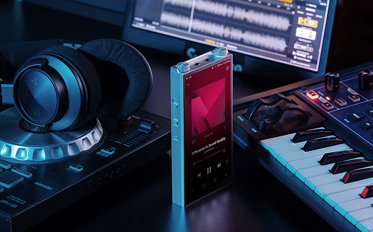 The Astell & Kern PD20 between a pair of headphones and a keyboard
