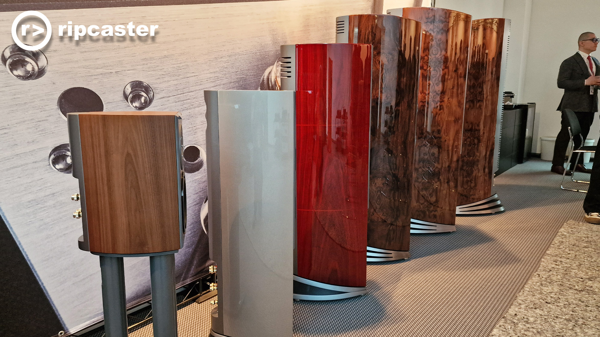 A line of Audiovector speakers with a man to the right of the image