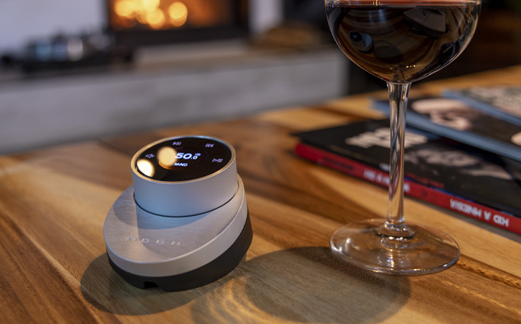 MOON BRM-1 remote control on a wooden table with a glass of wine beside it