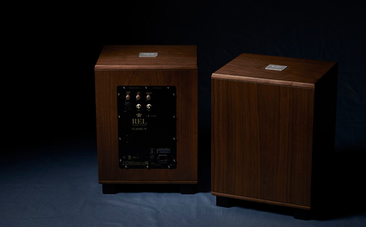 A pair of REL Classic 98 subwoofers, one viewed from the front, and one from the rear.