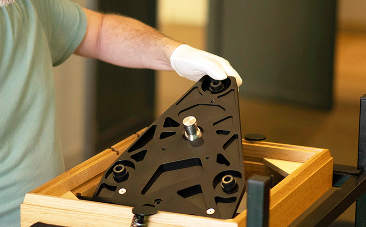 The Linn Keel SE being fitted into the plinth by a man in white gloves