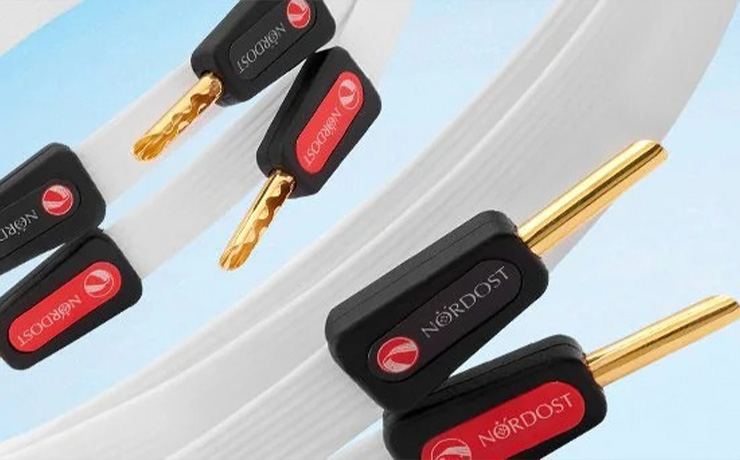 Nordost White Lightning speaker cables with banana connectors with a pale blue background