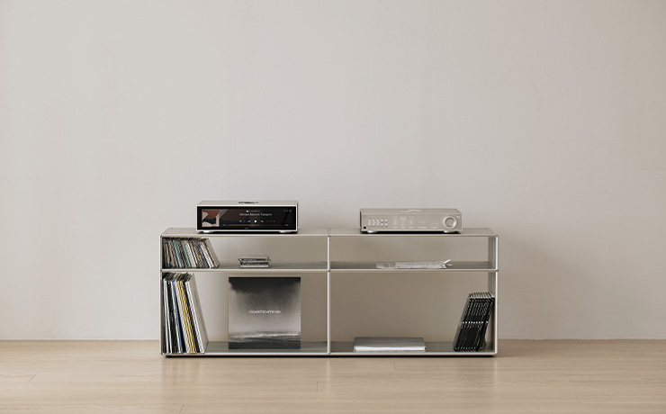 A shelving unit with albums on the bottom shelf. On the top of the unit is the HiFi Rose RD160 and the RS130.. There are no cables visible.