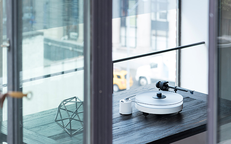 Project RPM 5 Carbon Turntable on a wooden table in front of a window