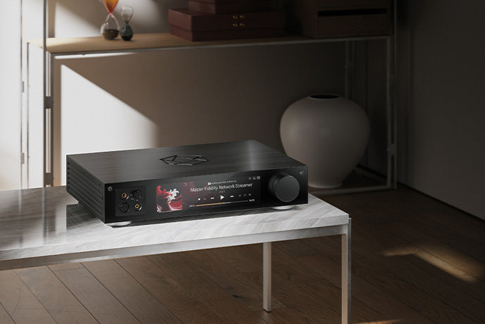 The HiFi Rose RS451 in black on a low bench table with shelving behind it