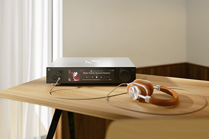 The HiFi Rose RS451 in silver on a wooden table with a pair of headphones plugged into the front