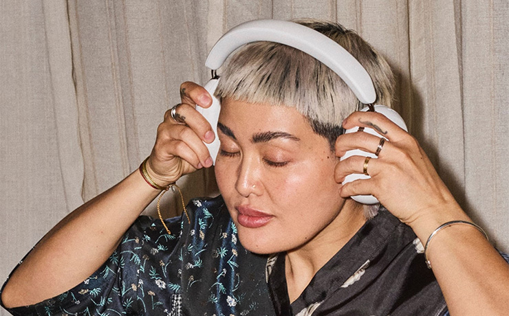 SONOS Ace Ultra in white on the head of a woman who is placing them on her head