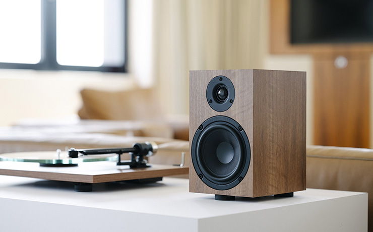 A walnut Project Speaker Box 5 E beside a walnut turntable