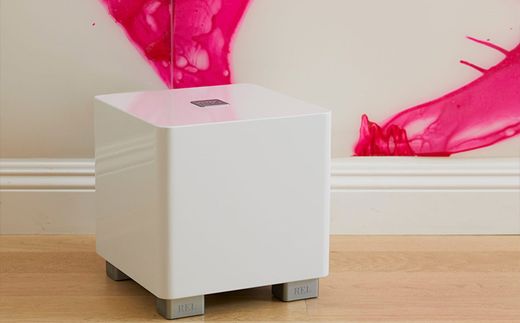 REL T/5x in white on a wooden floor in front of a cream coloured wall that has splashes of vibrant pink