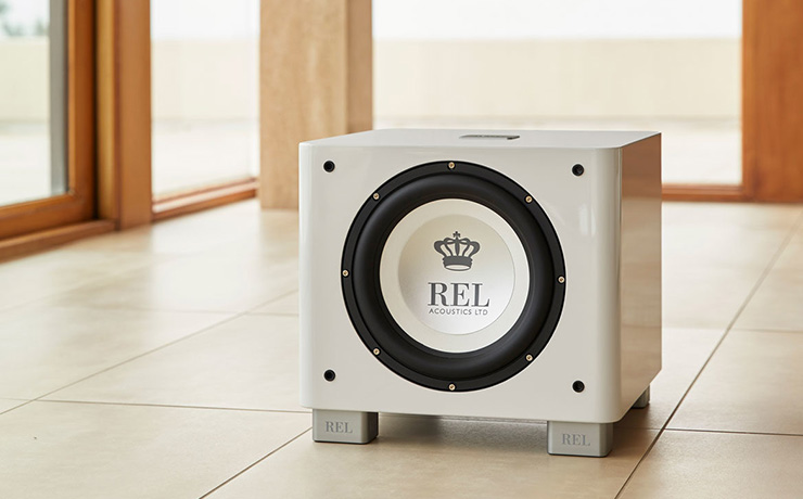 REL T/9x subwoofer in white on a cream tiled floor