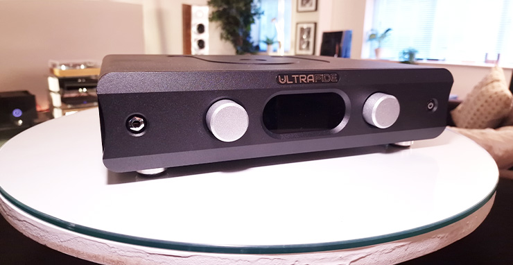 Ultrafide U4PRE Audiophile Pre-Amplifier on a white table. There are other HiFi items in the background
