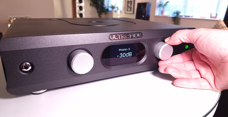 Ultrafide U4PRE Audiophile Pre-Amplifier with a hand operating a control.