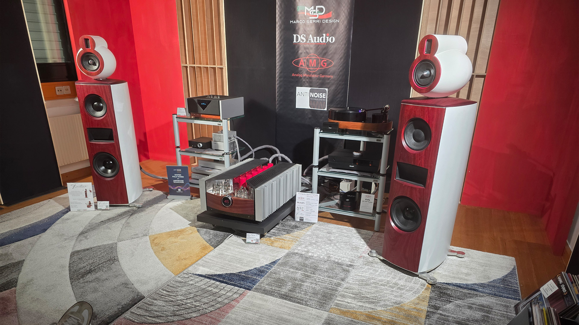 Two red floorstanding speakers with other HiFi units