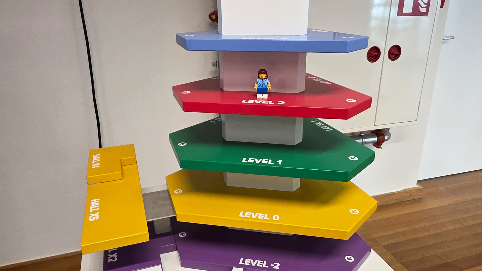 A colourful plan of the exhibition hall with a Lego figure on level 2