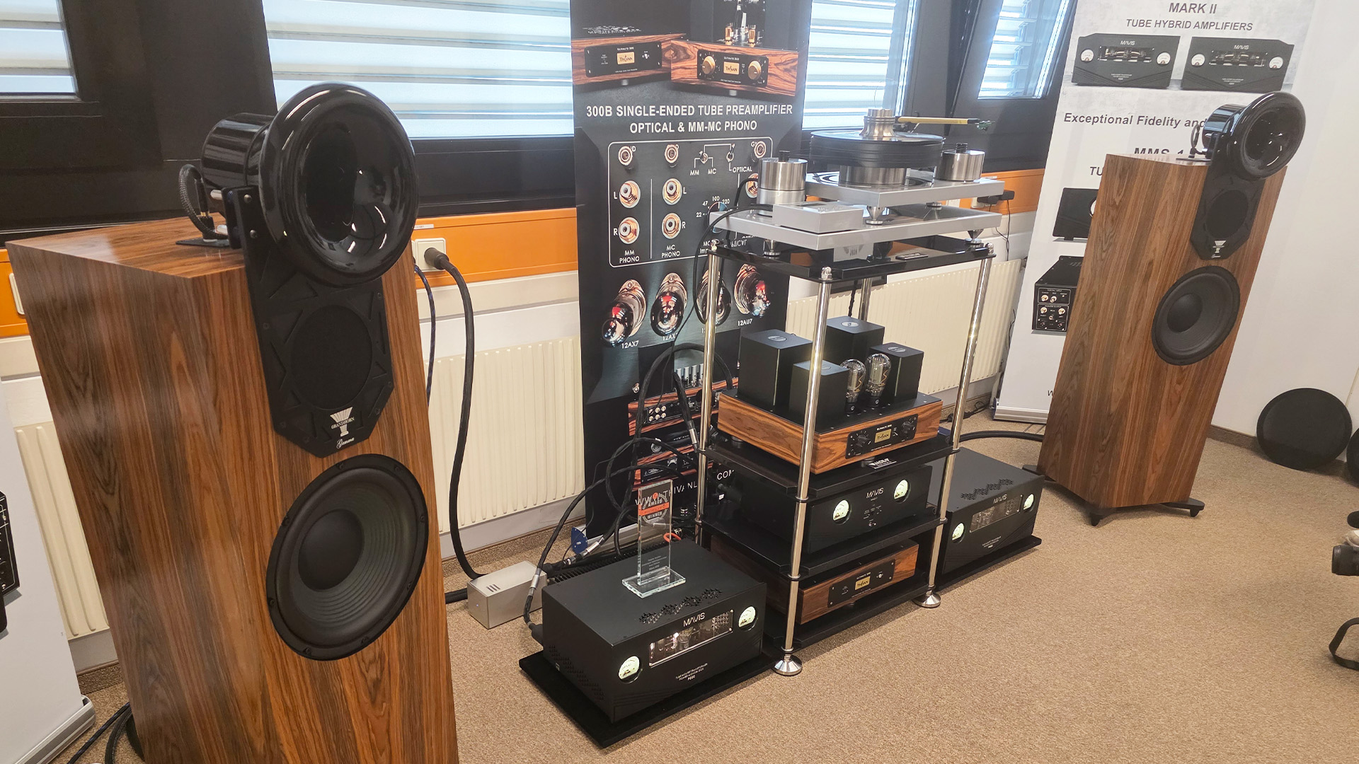 Floorstanding speakers with a wood finish and various pieces of HiFi kit in between