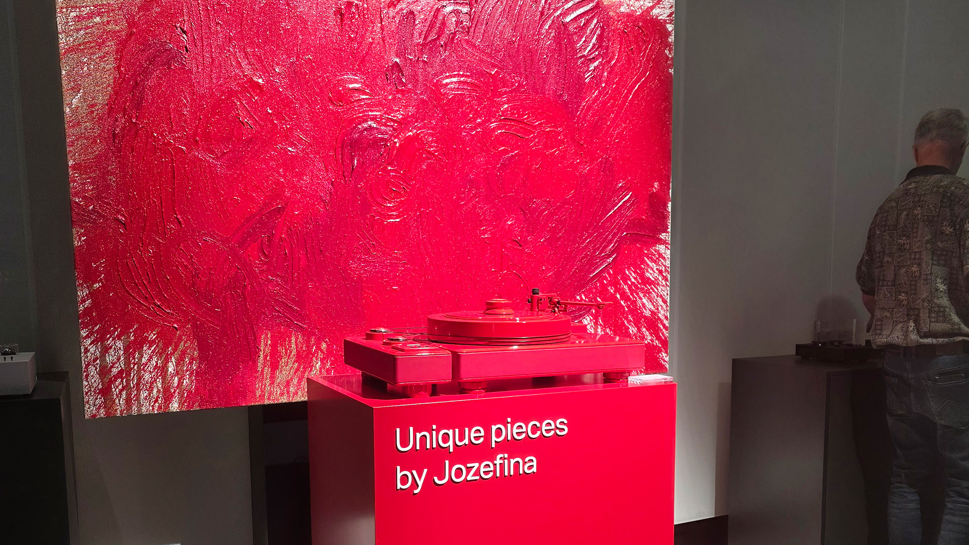 A bright red painting with a bright red turntable in front of it