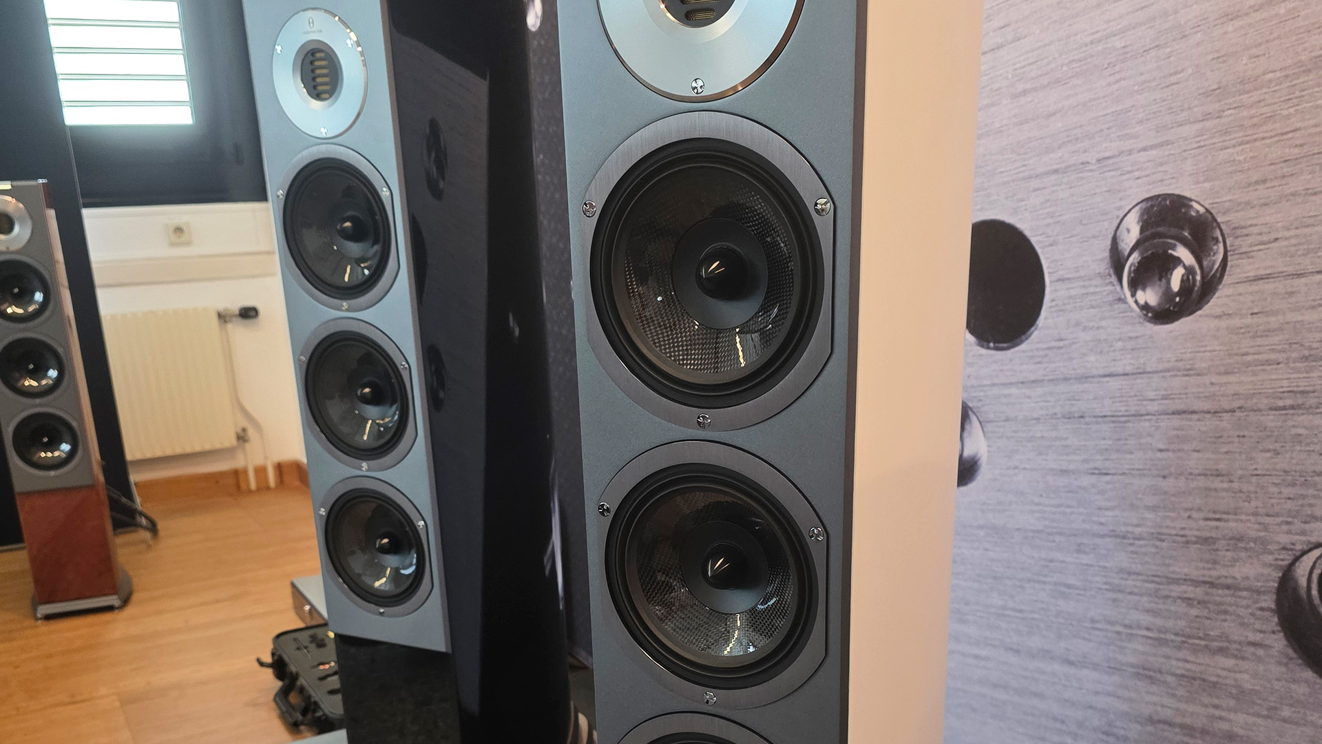 Three Audiovector floostanding speakers.  Each is in a different finish