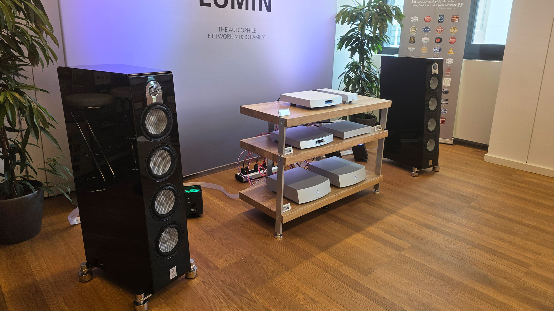A pair of black speakers with a selection of Lumin units between 