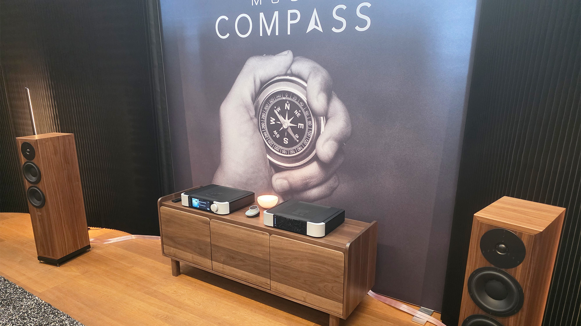 The MOON compass collection in between a pair of floorstanding speakers