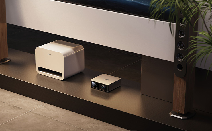 The WiiM Pro Sub in white on a low shelf beside a WiiM Streamer