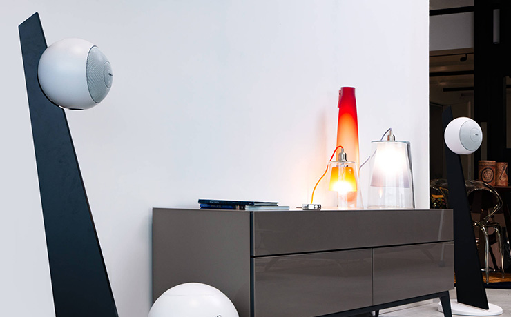 Cabasse Riga 2 speakers on stands in a living space either side of a sideboard