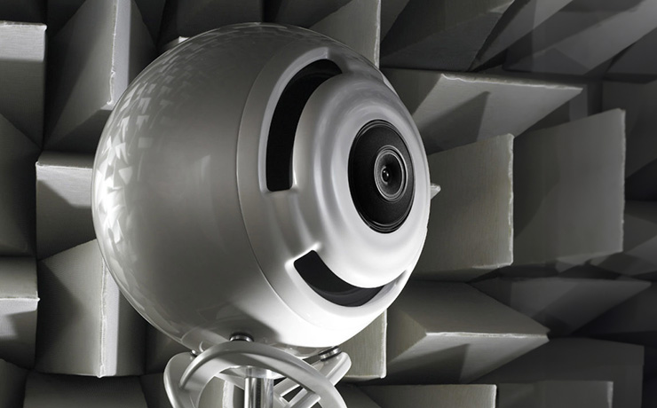 cabasse la sphere in white on a background of raised geometric shapes. Only the sphere and a small part of the base is visible. it's white.