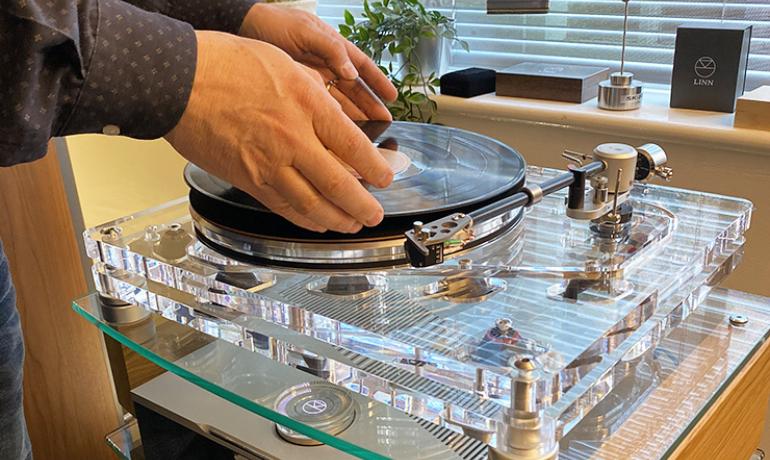 Vertere MG-1 MKII turntable with a man putting a record on a turntable