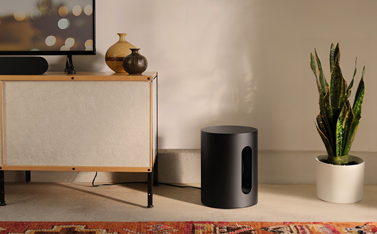 Sonos Sub Mini on the floor beside a tv unit