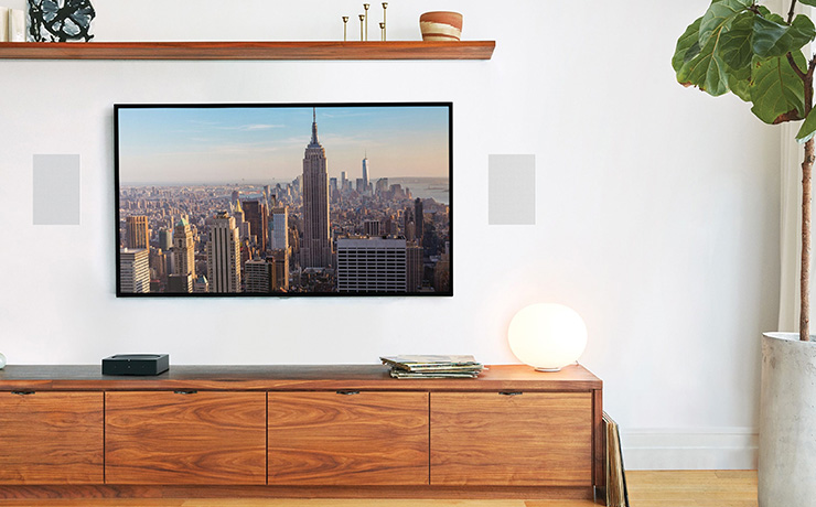 A pair of Sonos in-wall speakers either side of the tv. There's a low unit underneath the tv